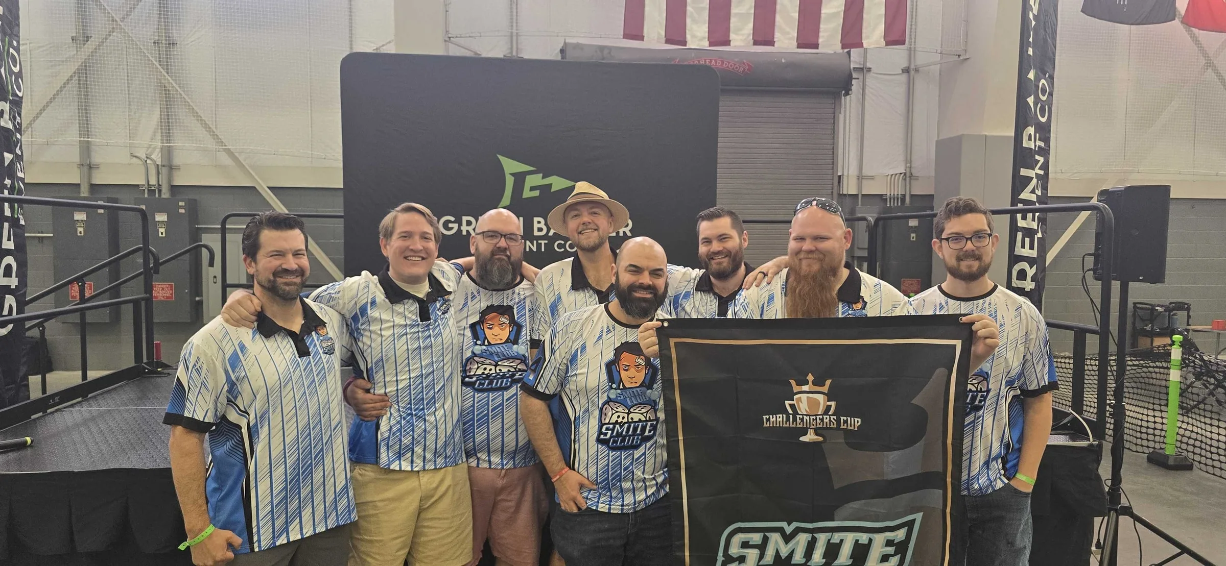 Smite Club's travel team in blue and white jerseys holding the team banner at Challengers Cup