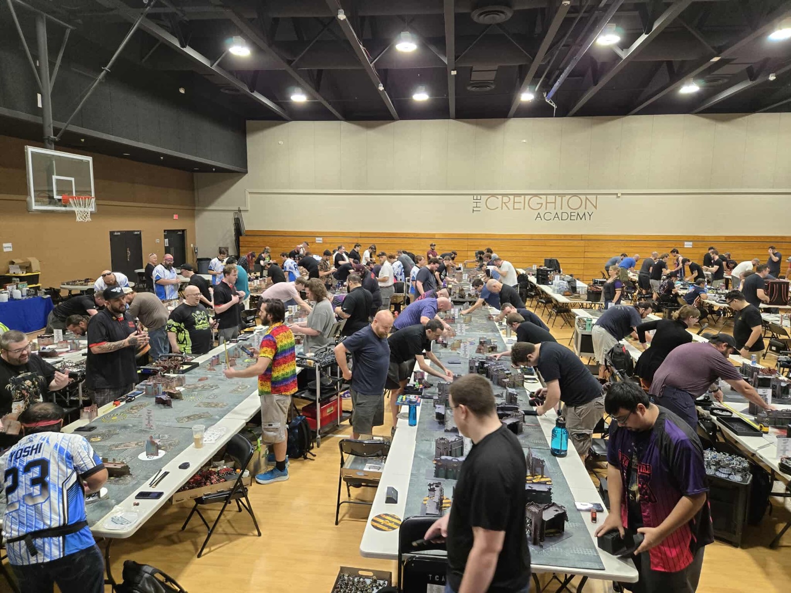 Players gather around rows of gaming tables at Smite Club Open 2025