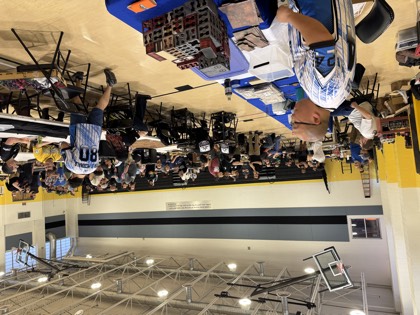 Players in club jerseys at tables beside the main floor