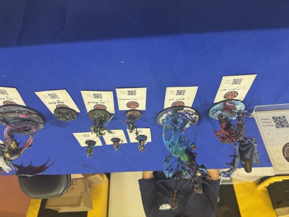 Painted miniature entries lined up on the Phoenix Miniature Painting Open table