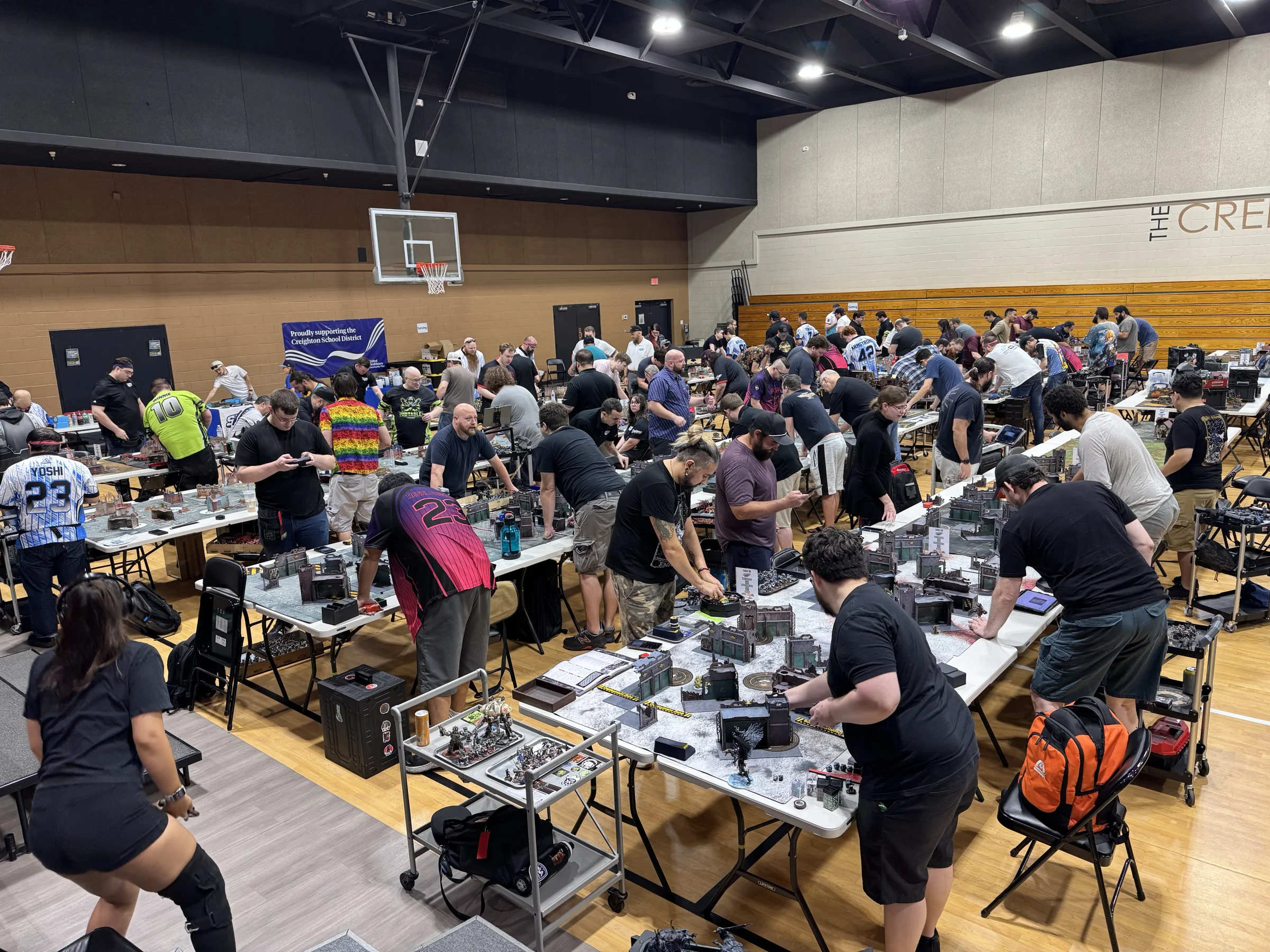 A full tournament room of tabletop players competing at a Smite Club event